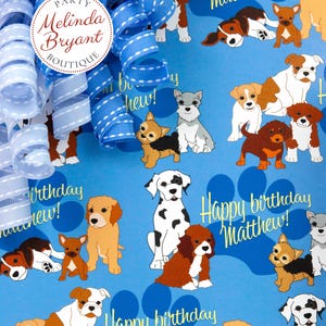 May include: Blue wrapping paper with a repeating pattern of dogs and paw prints. The text "Happy birthday Matthew!" is repeated throughout the paper.