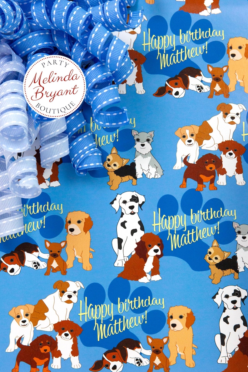 May include: Blue wrapping paper with a repeating pattern of dogs and paw prints. The text "Happy birthday Matthew!" is repeated throughout the paper.