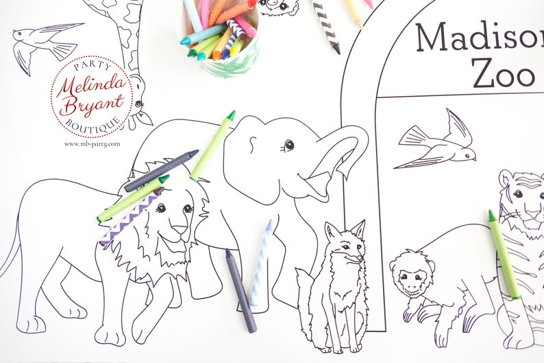 May include: A large white coloring sheet featuring outlines of zoo animals, including a lion, elephant, tiger, and monkey. Crayons in various colors are scattered around the sheet. The words "Madison Zoo" are printed at the top.