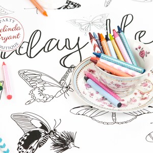 A pretty teacup and saucer filled with crayons are an invitation to sit down and color this pretty butterfly table runner.