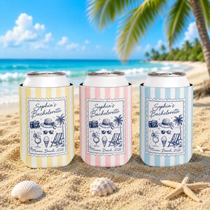 Puede incluir: Tres enfriadores de latas cilíndricos en amarillo, rosa y azul claro con rayas verticales blancas. Cada uno presenta un gráfico rectangular estilo sello con el texto "Sophia's Bachelorette" y "Miami Beach, 2026" junto a ilustraciones de una cámara, sombrero, palmera, gafas de sol, cóctel, helado y silla de playa.