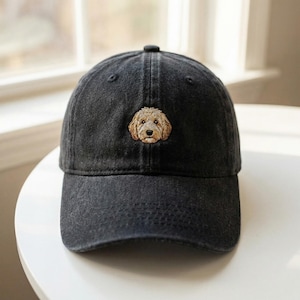 Könnte beinhalten: Schwarze Baseballkappe mit gebogenem Schirm. Auf der Kappe ist ein gesticktes Bild eines Golden Doodle Hundes auf der Vorderseite. Die Kappe ist aus weichem, strapazierfähigem Stoff gefertigt.