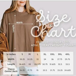 Op de afbeelding: Een bruin Comfort Colors 1717 zwaar t-shirt voor volwassenen met een maattabel. De tabel toont de afmetingen in cm voor breedte, lengte en mouwrug voor de maten S t/m 4XL.