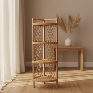 May include: A natural-toned, four-tiered corner shelf made of woven rattan. The shelves are triangular, with an open design featuring crisscross supports. The shelf is freestanding and sits on four short legs. The background includes a wooden table and a vase with dried plants.