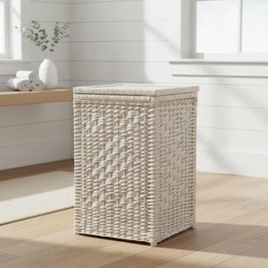 May include: A rectangular laundry hamper constructed from off-white woven wicker material. The hamper features a flat, matching lid that sits flush on top of the vertical, boxy frame. The weave pattern is consistent across all four sides of the unit.