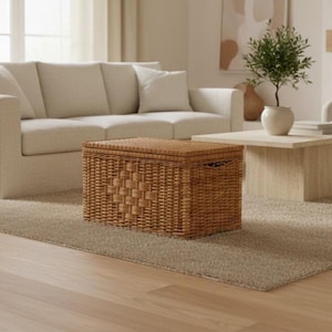 May include: A rectangular storage chest crafted from light brown woven wicker. The chest features a flat, hinged lid and a decorative diamond-shaped pattern woven into the front panel. It includes integrated side handles for lifting and moving.