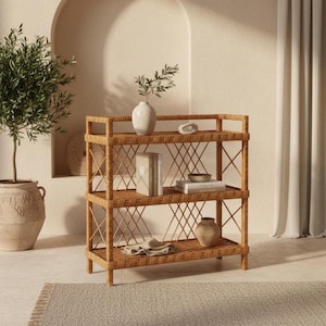 Puede incluir: Una estantería rectangular de tres niveles fabricada en ratán trenzado de color marrón claro. La estructura presenta un patrón de celosía entrecruzada en los laterales y la parte trasera, con cuatro patas verticales que sostienen el marco.