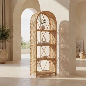 Puede incluir: Una estantería alta con forma de arco fabricada en ratán tejido de color claro. La estructura cuenta con cuatro estantes horizontales sostenidos por un marco tipo rejilla con refuerzos en cruz en los laterales y en la parte trasera.