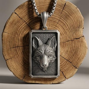 Op de afbeelding: Een rechthoekige zilverkleurige hanger met een gedetailleerd, verhoogd reliëf van een vossenkop op een getextureerde achtergrond. De hanger hangt aan een zilverkleurige boxketting en toont een metalen afwerking met gedetailleerde vachtstructuren.