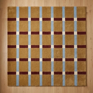 Könnte beinhalten: Ein quadratischer Teppich mit einem Gittermuster aus großen senfgelben Blöcken, die durch vertikale hellblaue Streifen und horizontale dunkelkastanienbraune Streifen getrennt sind, mit kleinen weißen Quadraten an den Schnittpunkten.
