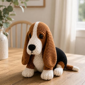 May include: A crocheted stuffed animal shaped like a Basset Hound dog. The toy features a tricolor pattern with brown, black, and white yarn, long floppy ears, a white stripe on the face, and black plastic eyes with a black stitched nose.