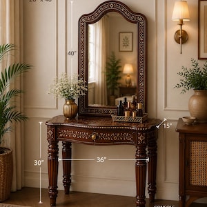 May include: A dark wood vanity set with a mirror (26" x 40") and console (36" x 15" x 30"). The mirror and console feature intricate inlaid designs. The console has a drawer and is supported by carved legs. A vase of flowers sits on the console.