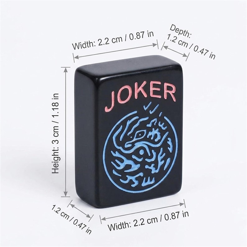 Może przedstawiać: Czarny prostokątny kafelek do gry ze słowem "JOKER" w kolorze r&oacute;żowym i niebieskim wzorem. Płytka ma 3 cm wysokości, 2,2 cm szerokości i 1,2 cm głębokości. Element gry do gier planszowych.