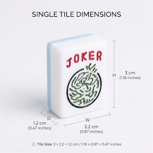 以下が含まれることがあります： 赤色の「JOKER」の文字と緑と黒のデザインが施された白い麻雀牌。牌の高さは3cm、幅は2.2cm、奥行きは1.2cmです。牌には水色の縁があり、「SINGLE TILE DIMENSIONS」という文字があります。