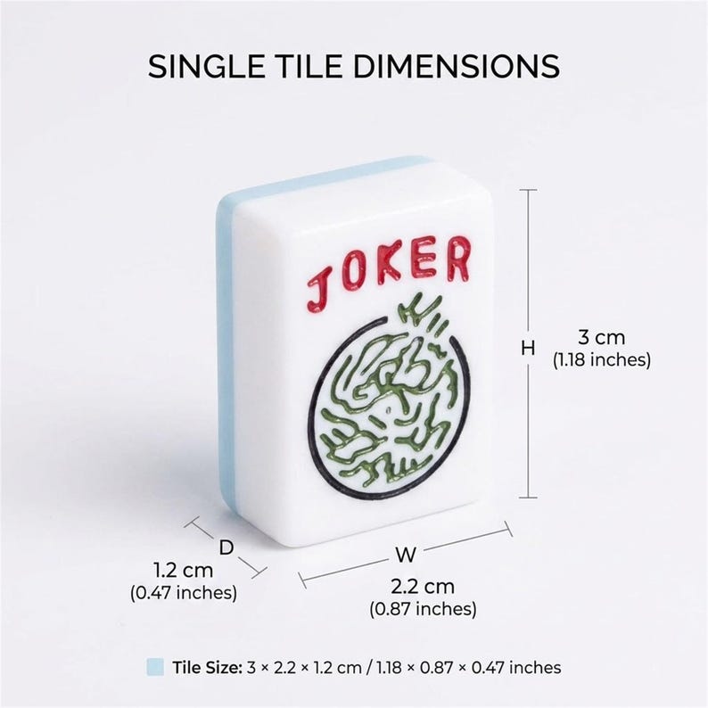 以下が含まれることがあります： 赤色の「JOKER」の文字と緑と黒のデザインが施された白い麻雀牌。牌の高さは3cm、幅は2.2cm、奥行きは1.2cmです。牌には水色の縁があり、「SINGLE TILE DIMENSIONS」という文字があります。
