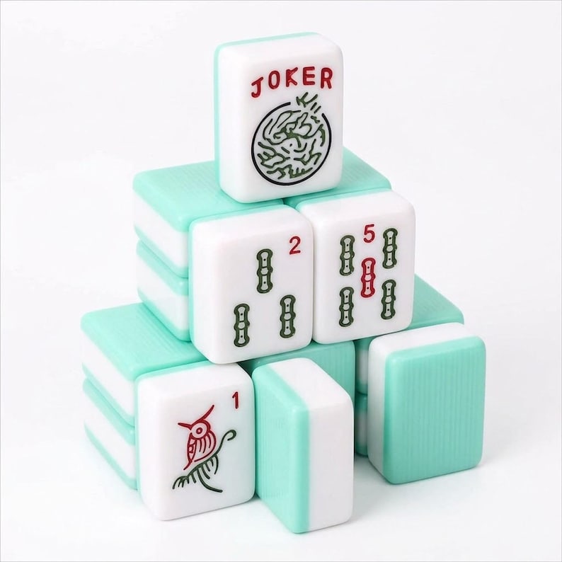 May include: A stack of Mahjong tiles with white faces and teal backs. The tiles display various symbols, numbers, and the word "JOKER". The "JOKER" tile has a circular design. The number tiles show the numbers 1, 2, and 5.