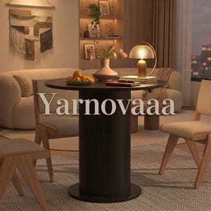 May include: A round black dining table with a fluted cylindrical base, featuring the text Yarnovaaa overlaid in the center. The table is set with a light pink vase containing tulips, a small bowl of oranges, and a gold-toned mushroom lamp.