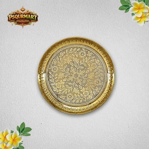 May include: A round, metallic gold-coloured tray featuring an intricate, embossed floral pattern across its surface. The design includes detailed leaves and flowers, with a textured border along the rim. The tray is presented on a plain background.