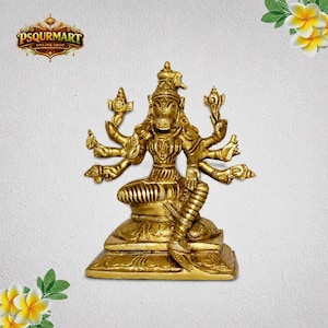 May include: A gold-colored statue of a multi-armed deity, seated on a tiered base. The figure has a distinctive animal-like head and is adorned with intricate details. The statue is from the online shop PSQURMART.