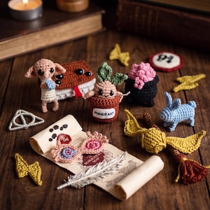 May include: A collection of handmade crochet items, including a Dobby figure, a Mandrake plant in a pot, a blue bunny, and a golden snitch. Other items include a book, a pair of glasses, and a scroll. The items are arranged on a wooden surface.