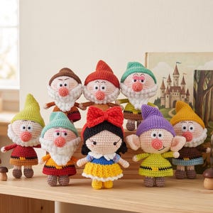 May include: A collection of eight crocheted dolls featuring a central figure with black hair and a large red bow, surrounded by seven smaller figures with pointed hats, white beards, and round pink noses, all crafted with detailed yarn textures.