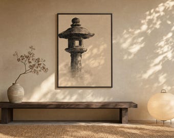 May include: A framed wall art print featuring a dark, charcoal-toned illustration of a traditional stone lantern. The artwork is displayed on a light beige wall above a long, dark wooden bench, accompanied by a ceramic vase and a round paper lamp.