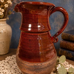 Vintage speckled brown glazed stoneware studio pottery pitcher with spiral handle.