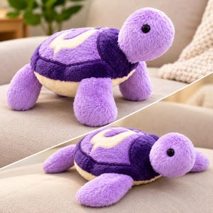 May include: A plush turtle toy featuring a soft lavender body, a dark purple shell with a cream-colored emblem, and a cream-colored underside. The stuffed animal has black plastic eyes and a fuzzy texture, shown from two different angles.