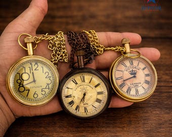 Reloj de bolsillo antiguo de latón / Esfera dorada con números romanos, cadena incluida.