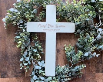 May include: White wooden cross with the text "Carolyn Sloan Lewandowski Baptized 08.25.2019" engraved in rose gold.