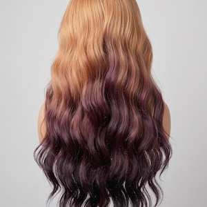 May include: A long, wavy wig featuring a two-tone color gradient. The top section is a warm, light golden-brown shade that transitions into a deep, dark plum purple color at the ends. The hair has a soft, flowing texture with loose, voluminous waves.