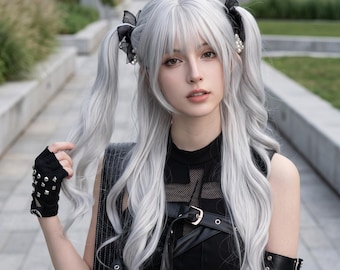Könnte beinhalten: Eine lange silberweiße Perücke, gestylt in zwei hohen Zöpfen mit schwarzen Schleifen und Perlenakzenten. Die Perücke hat einen geraden Pony und lange, gewellte Längen. Sie ist für Cosplay und Kostüme konzipiert und wirkt sehr voluminös.