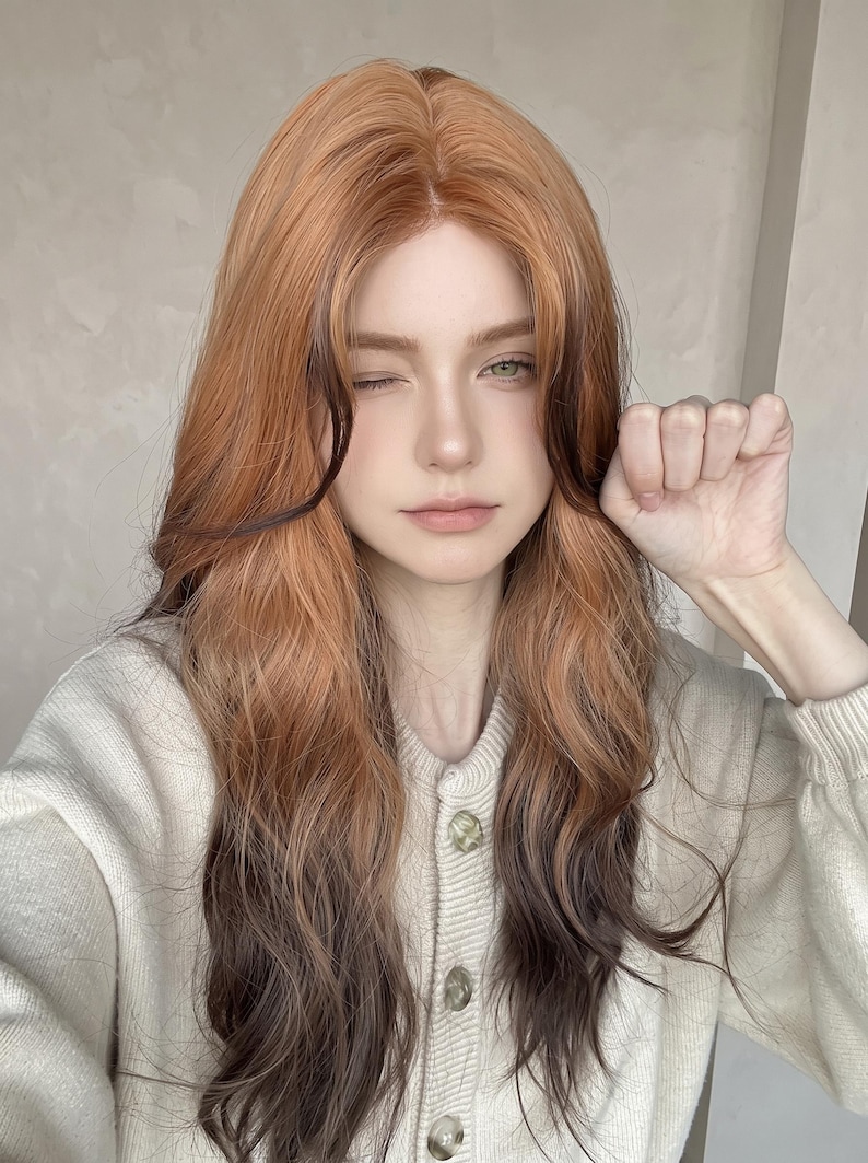 May include: A long, wavy wig featuring a gradient color transition from a warm ginger-orange at the roots to a deep, dark brown at the ends. The hair is parted in the center, with face-framing layers that blend the two distinct color tones.