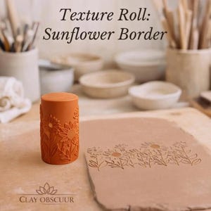 Op de afbeelding: Een cilindervormige, terracotta-kleurige textuurrol met een zonnebloemrandpatroon, geplaatst naast een plat stuk klei dat is bedrukt met hetzelfde zonnebloemontwerp. De tekst "Texture Roll: Sunflower Border" en "CLAY OBSCUUR" is zichtbaar.