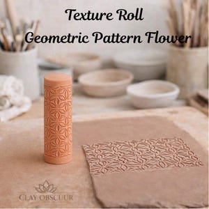 Op de afbeelding: Een cilindervormige, perzikkleurige kleitextuurrol met een geometrisch bloemenpatroon. Het gereedschap staat rechtop naast een plat stuk klei dat hetzelfde reliëfpatroon vertoont. Tekst: Texture Roll Geometric Pattern Flower.