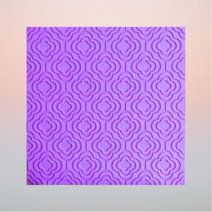 Op de afbeelding: Een vierkant paars vel met een herhalend reliëfpatroon van vierpassen. Het ontwerp bestaat uit onderling verbonden vierlobbige vormen met verhoogde randen, wat zorgt voor een gestructureerd oppervlak met consistente geometrische diepte.