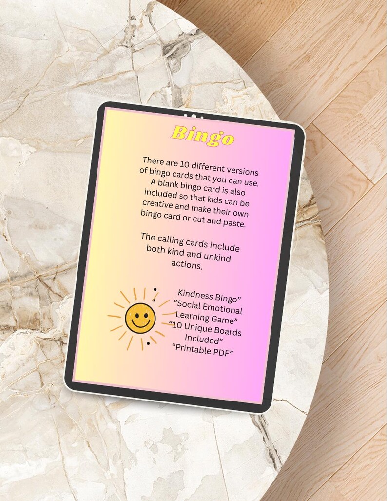 Peut inclure: Une tablette num&eacute;rique affiche un jeu de Bingo avec un fond d&eacute;grad&eacute; rose et jaune. Le texte comprend "Kindness Bingo", "Social Emotional Learning Game" et "10 Unique Boards Included".