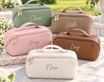 May include: Five rectangular cosmetic bags with top handles and gold-tone zips. The bags are in sage green, tan, light pink, brown, and cream, each featuring a custom name in cursive script: Claire, Stella, Avery, Lucy, and Nora respectively.