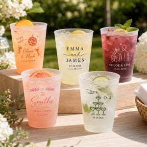 May include: Five frosted plastic cups filled with colorful beverages and ice. Each cup features custom printed designs including names, dates, and graphics like a disco ball, a wedding couple, a champagne tower, and floral accents.