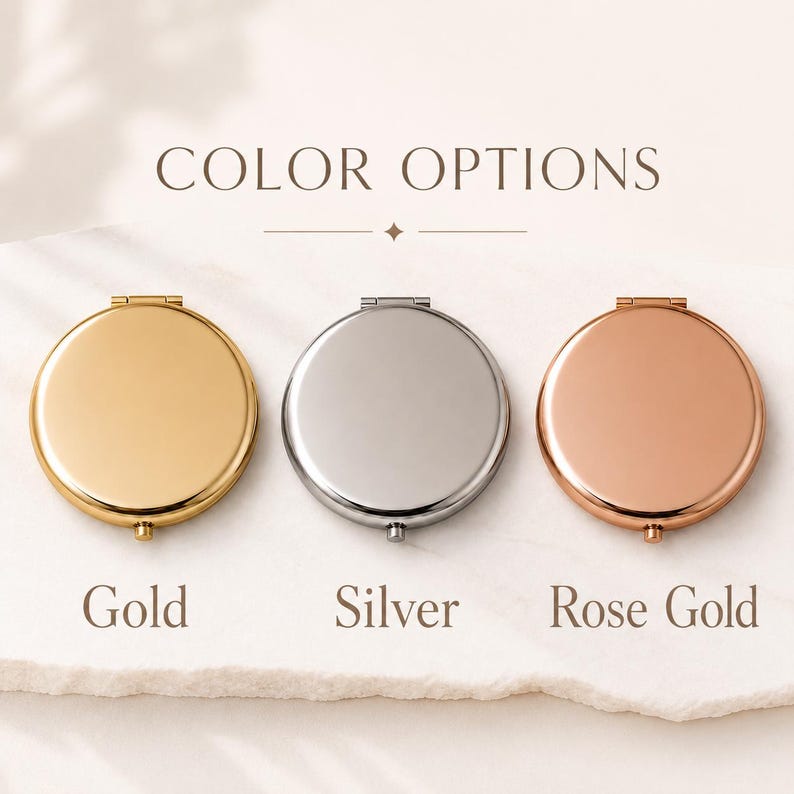 May include: Three round compact mirrors arranged horizontally, labelled with the text COLOR OPTIONS. The mirrors are finished in gold, silver, and rose gold metallic tones, each featuring a small hinge at the top and a clasp at the bottom.