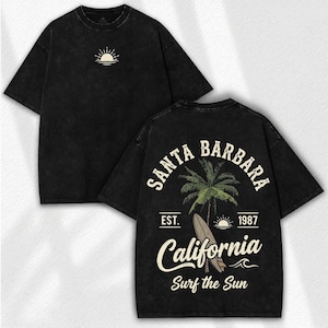 May include: Black t-shirt with a distressed look. The front features a small sun graphic. The back displays a Santa Barbara, California design with a palm tree, surfboard, and the text "Surf the Sun."