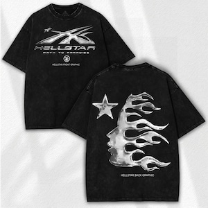 May include: Black t-shirt with a distressed look, featuring a metallic silver graphic on the front that reads "HELLSTAR PATH TO PARADISE". The back of the shirt has a star and a face with a flame design. "HELLSTAR FRONT GRAPHIC" and "HELLSTAR BACK GRAPHIC" are also printed.