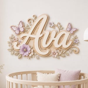 Könnte beinhalten: Ein Wand-Namensschild aus Holz mit dem Namen Ava in weißer Schreibschrift auf einem hellen Holzuntergrund. Das Design ist mit dreidimensionalen hellvioletten Schmetterlingen, zarten lavendelfarbenen Blüten und filigranen Blattmotiven verziert.