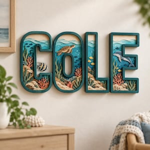 Puede incluir: Un conjunto de cuatro letras tridimensionales grandes de color verde azulado oscuro que forman el nombre COLE. Cada letra presenta una escena oceánica recortada en capas con arena, coral, algas y vida marina, incluyendo una tortuga.