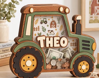 May include: A wooden tractor-shaped piggy bank with a clear front panel, featuring the name THEO in raised letters. The design includes green, brown, and yellow accents, with a patterned background showing farm icons like cows and barns.