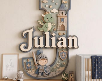 May include: A large, layered wooden wall decoration shaped like the letter J, featuring the name Julian in raised lettering. The design includes a green dragon, a stone castle, a knight with a sword and shield, and small stars in blue and beige.