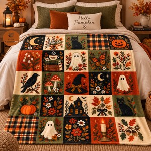 Op de afbeelding: Een rechthoekige plaid met een raster van herfstachtige illustraties, waaronder pompoenen, zwarte katten, spoken, paddenstoelen, een heksenhoed, een spookhuis, een maansikkel, bloemstukken en ruitpatronen in oranje, groen en zwart.
