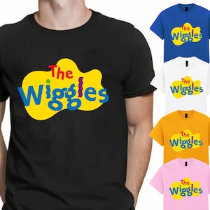 May include: Black t-shirt with "The Wiggles" logo in yellow, blue, and red. Other t-shirts in blue, white, gold, and pink, each displaying the same logo, are also shown.