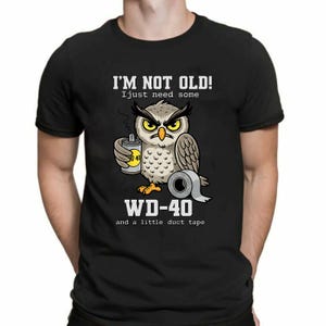 May include: Black t-shirt with a cartoon owl graphic holding a WD-40 can and duct tape. The text on the shirt says "I'M NOT OLD! I just need some WD-40 and a little duct tape."
