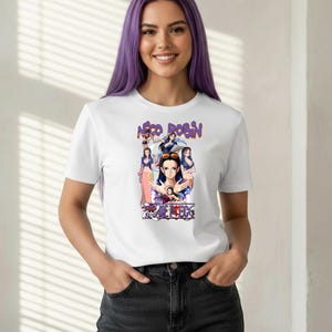 May include: White t-shirt featuring a graphic of the character Nico Robin from the anime series One Piece. The design includes multiple images of the character and the text "Nico Robin" and "One Piece".